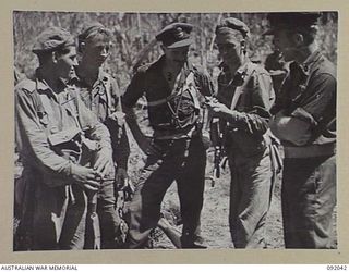 BOUGAINVILLE, 1945-05-16. PILOTS OF THE ROYAL NEW ZEALAND AIR FORCE VISITED A FORWARD COMPANY OF 24 INFANTRY BATTALION TO VIEW THE RESULT OF THEIR BOMBING IN SUPPORT OF THE INFANTRY ADVANCE. THEY ..