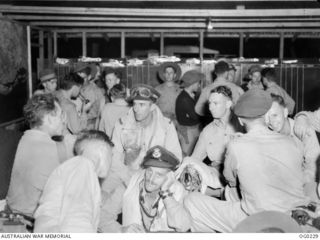 MILNE BAY, PAPUA. 1943-11-14. TIRED BEAUFORT BOMBER CREWS OF NO. 6 SQUADRON RAAF WAITING THEIR TURN FOR INTERROGATION AFTER TAKING PART IN THE LARGEST ALL RAAF RAID ON RABAUL ON SUNDAY NIGHT. THE ..