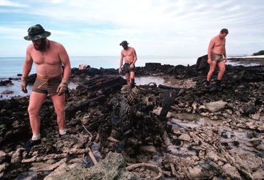 Air Force and Navy demolition disposal experts search for live World War II explosives on the island of Enjebi. Artillery shells, mines, grenades, and bombs are still found on the island. Enjebi, part of Eniwetok Atoll, was used as an atomic testing area in the 1950s