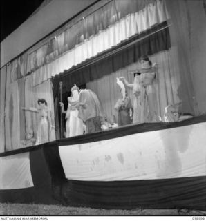 KONEDOBU (KANEDABU), NEW GUINEA. 1943-10-27. A PERSIAN MARKET SCENE PERFORMED ON STAGE DURING THE SHOW BY THE 7TH AUSTRALIAN DIVISION CONCERT PARTY. SHOWN: VX17900 SERGEANT (SGT) D. C. LEED (1); ..