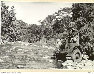 LEMLONG RIVER, NEW BRITAIN. 1945-02-08. SX9356 GUNNER W.C. KLUSKE (1) AND SX10544 GUNNER K. PETRIE (2) 2/14TH FIELD REGIMENT GETTING THE UNIT WATER SUPPLY FROM ONE OF THE RIVERS IN THE AREA