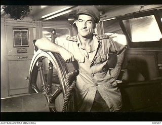 Port Moresby, New Guinea. 12944-06-15. Portrait of Captain D. F. Herbert, 12 Water Transport Operating Company, Royal Australian Engineers (RAE), Skipper, in the wheelhouse of the unit vessel, AK94