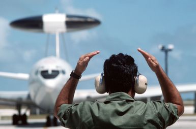 An airman guides a taxiing E-3A Sentry aircraft during exercise Giant Warrior '89