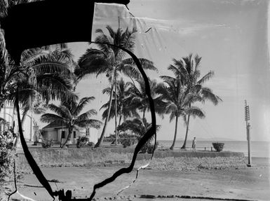 [Woman standing atop a sea wall in the Pacific Islands]