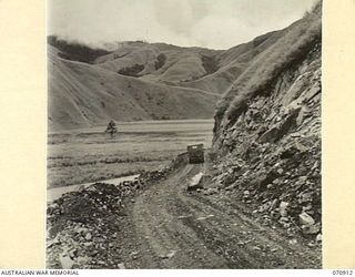 WAU - LAE ROAD, NEW GUINEA, 1944-02-26. A PARTLY COMPLETED ROAD BENCH, THIRTY THREE AND A QUARTER MILES FROM WAU. THE ROAD AT THIS POINT IS MAINTAINED BY THE 1ST MECHANICAL EQUIPMENT PLATOON, 2/1ST ..