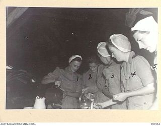 TOROKINA, BOUGAINVILLE, 1945-04-18. SISTER E.M. DUFFIELD (1), POURING TEA FOR BREAKFAST AT 2/1 GENERAL HOSPITAL. IDENTIFIED PERSONNEL ARE:- SISTER M. WALL (2); SISTER E.M. ALLEN (3); SISTER E.A. ..