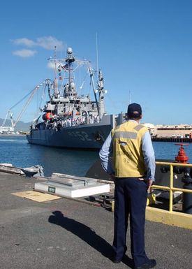 A US Navy (USN) Line Handler watches as the Safeguard Class: Salvage Ship USS SALVOR (ARS 52) pulls into Pearl Harbor, Hawaii, following a deployment to participate in the Cooperation Afloat Readiness and Training (CARAT) Exercise 2004. CARAT is a regularly scheduled series of bilateral military training exercises designed to enhance the combat readiness of the respective sea services in the Western Pacific Region