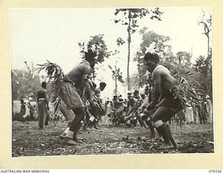 MANGUNUI, JACQUINOT BAY, NEW BRITAIN. 1945-02-25. NATIVES PERFORMING ONE OF THEIR TRIBAL DANCES DURING A SING- SING AT THE AUSTRALIAN NEW GUINEA ADMINISTRATIVE UNIT NATIVE COMPOUND