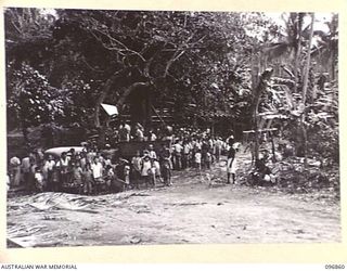 RATONGOR, NEW BRITAIN. 1945-09-13. INTERNEES CROWD AROUND THE MAIN ENTRANCE TO THE CHINESE INTERNMENT CAMP TO GREET REPRESENTATIVES OF THE AUSTRALIAN RED CROSS. THE REPRESENTATIVES CONTACTED THE ..