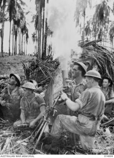 GIROPA POINT, PAPUA. THE FINAL ASSAULT ON BUNA. AN AUSTRALIAN MORTAR CREW FROM HEADQUARTERS COMPANY, 2/12TH BATTALION, LAYS DOWN A BARRAGE AS INFANTRY ADVANCES TO ATTACK A JAPANESE PILLBOX. LEFT TO ..