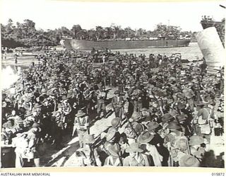 1943-09-29. NEW GUINEA. ATTACK ON FINSCHHAFEN. AT THE EMBARKATION POINT AUSTRALIAN TROOPS THRONG THE BEACH AWAITING ORDERS TO BOARD A LANDING BARGE. (NEGATIVE BY MILITARY HISTORY NEGATIVES)