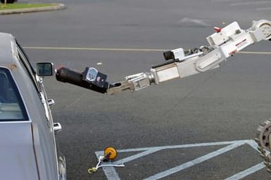 A Remote Operated Neutralization System, pulls out a simulated bomb from the back window of a car during training at the Marine Corps Base Hawaii, Post Exchange parking lot on Dec. 9, 2004.(U.S. Marine Corps official photo by CPL. Nicholas Riddle) (Released)