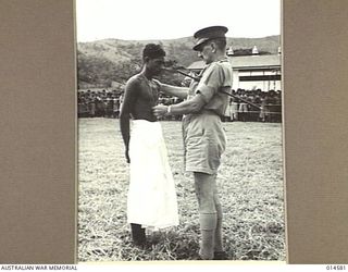 1943-04-05. NEW GUINEA. THE RESCUE OF TWO AMERICAN SOLDIERS FROM A FLOODED RIVER IN NEW GUINEA EARNED THE COMMONWEALTH MEDAL FOR LOYAL SERVICE TO PAUL MEA, A PAPUAN SCHOOLBOY. HERE PAUL IS BEING ..