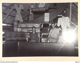 LAE, NEW GUINEA. 1945-11-12. SERGEANT R. BLAKE (1) AND WARRANT OFFICER 2 D.H. MCLEOD (2) IN THE INTERIOR OF 8 SECTION AUSTRALIAN OFFICERS' SHOP