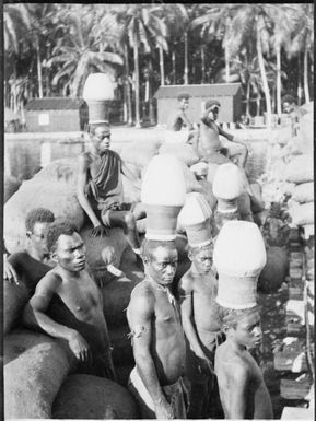 Five men wearing Ombu, ceremonial headwear, those in the foreground are facing the camera, Soraken, Bougainville Island,  ca. 1929 / Sarah Chinnery