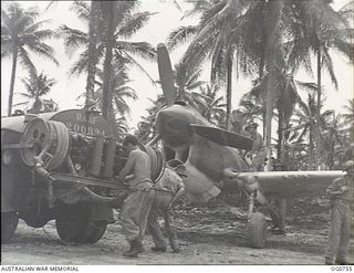 MOMOTE, LOS NEGROS ISLAND, ADMIRALTY ISLANDS. 1944-03-08. AIRMEN REFUELLING A RAAF KITTYHAWK AIRCRAFT ON MOMOTE STRIP. A GUARD STANDS HANDY WITH A TOMMY-GUN IN CASE STRAY JAPANESE SHOULD ATTEMPT TO ..