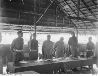 CAPE WOM, NEW GUINEA, 1945-12-01. LIEUTENANT-COLONEL A.G. CAMERON (3) SWEARING IN MAJOR V. CORR (2) AT THE TRIAL OF LIEUTENANT TAZAKI, WHO WAS CHARGED WITH AND LATER SENTENCED TO DEATH FOR ..