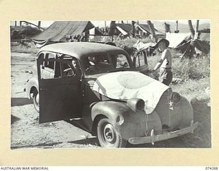HANSA BAY, NEW GUINEA. 1944-06-22. QX35803 SIGNALLER O'KEEFE (1) AND QX57857 SIGNALLER J.V. DAVIDSON (2), 5TH DIVISION SIGNALS, WITH AN ABANDONED JAPANESE STAFF CAR WHICH THEY DISCOVERED AFTER THE ..