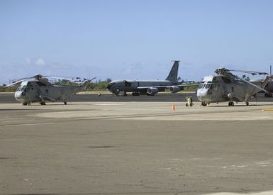 Right side front view long shot as United States Navy SH-3H Sea King Helicopters and an Air Force KC 135 Aerial Refeuler Stand ready to support RIMPAC 2000 on the Hickam AFB, HI flightline. 31 May 2000. RIMPAC stands for "Rim of the Pacific" is a major maritime exercise held every 2 years involving more than 50 ships and 200 aircraft