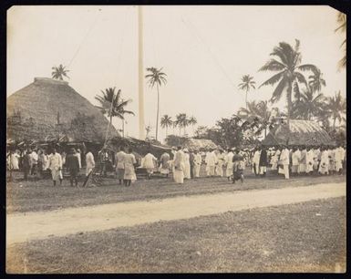 Crowd beneath a flagpole, Samoa.