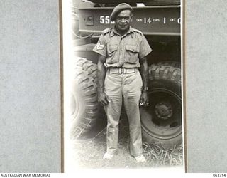 1944-01-26. SERGEANT H. R. MARTIN OF THE AUSTRALIAN AND NEW GUINEA ADMINISTRATION UNIT PHOTOGRAPHED NEAR A 20 TON TANK TRANSPORTER AT THE FACTORY OF THE FORD MOTOR COMPANY