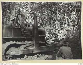 BOUGAINVILLE. 1945-04-17. A BULLDOZER OF 15 FIELD COMPANY ROYAL AUSTRALIAN ENGINEERS AT WORK FILLING IN DAWE CREEK TO ALLOW B SQUADRON 2/4 ARMOURED REGIMENT MATILDA TANKS AND 24 INFANTRY BATTALION ..