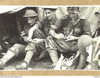 FINISTERRE RANGES, NEW GUINEA. 1944-01-23. STRETCHER BEARERS OF THE 2/9TH INFANTRY BATTALION HAVING A SPELL OUTSIDE THE REGIMENTAL AID POST DURING THE BATTLE FOR SHAGGY RIDGE. THEY ARE:- QX10865 ..