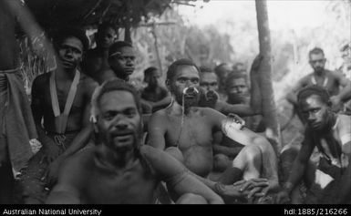 Group of men, mostly sitting