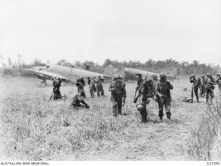 WANIGELA, NEW GUINEA. 1942-10. MEMBERS OF 3RD BATTALION, 128TH REGIMENT, 32ND U.S. DIVISION ALIGHTING FROM LOCKHEED HUDSON TRANSPORT AIRCRAFT ON A ROUGH RUN WAY ON THE SHORES OF COLLINGWOOD BAY, AS ..