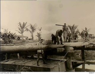 Milne Bay, New Guinea. 1943-07-12. Members of the 21st Field Company, Royal Australian Engineers, building a new bridge across Lauiam Creek as the previous one had fallen down