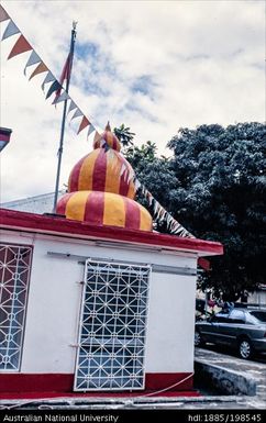 Fiji - white building, red-and-yellow striped dome, flags