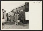 Family groups boarding buses at the Santa Ana Temporary Housing Project for transport to the Los Angeles Harbor and the