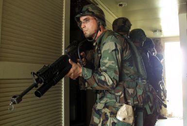 Armed with M16A2 service rifles, Marines from 31st Marine Expeditionary Unit (MEU), 2nd Battalion, 4th Marines, Fox Company, 3rd Platoon conduct Military Operations in Urban Terrain (MOUT) at an abandoned housing unit on Anderson Air Force Base (AFB), Guam in support of Exercise TANDEM THRUST 2003