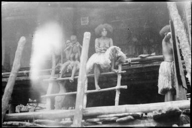 Two women and an infant seated on the verandah of a marine house, Papua, ca. 1923 / Sarah Chinnery