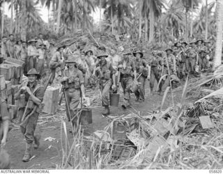 LANGEMAK BAY, NEW GUINEA. 1943-10-20. TROOPS OF THE 2/24TH AUSTRALIAN INFANTRY BATTALION MARCHING TO THE BEACH HEAD, PRIOR TO EMBARKING ON LANDING CRAFT, MECHANISED (LCM) AND LANDING CRAFT, VEHICLE ..
