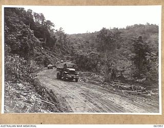 DREGER HARBOUR, NEW GUINEA. 1943-12-03. TRUCKS OF THE 870TH UNITED STATES AVIATION ENGINEER BATTALION CARTING CORAL ROCK TO BE USED IN THE CONSTRUCTION OF THE NEW LANGEMAK BAY-DREGER HARBOUR ROAD