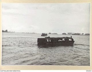 PURUATA ISLAND, SOUTH BOUGAINVILLE. 1945-05-29. LANDING CRAFT MECHANIZED OF 42 LANDING CRAFT COMPANY MOVING INTO POSITION TO TAKE A SWAMPED AUSTRALIAN LANDING CRAFT 5 IN TOW TO PURUATA ISLAND (AT ..