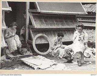 LAE, NEW GUINEA. 1945-05-08. AUSTRALIAN WOMEN'S ARMY SERVICE PERSONNEL, SETTLING IN AT THE NEWLY CONSTRUCTED AWAS BARRACKS IN BUTIBUM ROAD, MAKING BEDSIDE MATS BY SPLITTING HESSIAN BAGS IN TWO AND ..