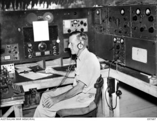 LAE, NEW GUINEA. 1945-10-05. CHIEF PETTY OFFICER TELEGRAPHIST J.T.(JACK) ALLAN, ROYAL AUSTRALIAN NAVAL VOLUNTEER RESERVE ON DUTY AT THE CONTROL WIRELESS STATION, ALLIED INTELLIGENCE BUREAU (AIB), ..