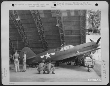 A Curtiss P-40 Which Has Been Converted Into A Two Passenger Plane For Observational Purposes Is Given A Final Check-Over By Men Of Trhe 27Th Air Depot Group At The Port Moresby Air Depot, Papua, New Guinea. 1943. (U.S. Air Force Number 67701AC)