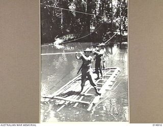 1943-05-07. NEW GUINEA. MILNE BAY. TROOPS ON PATROL DUTY CROSS A DEEP RIVER ON A SMALL NATIVE MADE BAMBOO RAFT. (NEGATIVE BY N. BROWN)