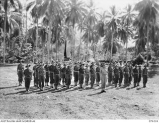 SIAR, NEW GUINEA. 1944-06-23. PERSONNEL OF BATTALION HEADQUARTERS, 57/60TH INFANTRY BATTALION STAND TO ATTENTION DURING THE MORNING PARADE. IDENTIFIED PERSONNEL ARE:- VX142143 STAFF SERGEANT N.G. ..