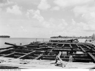 KAVIENG, NEW IRELAND, 1945-10-21. THE KAVIENG WHARF, MOST OF WHICH STILL STANDS. THE AUSTRALIAN NEW GUINEA ADMINISTRATIVE UNIT (ANGAU) ADMINISTRATIVE HEADQUARTERS IS BEING SET UP IN THE AREA WITH ..