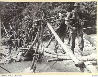 1943-08-09. NEW GUINEA. AUSTRALIAN CROSSING THE BITOI RIVER ON A MAKE-SHIFT BRIDGE. THERE WAS BITTER FIGHTING BETWEEN THE ALLIES AND THE JAPS AT BITOI RIVER FROM WHICH THE JAPANESE RETREATED TO ..