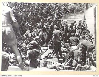 JABA RIVER AREA, BOUGAINVILLE, SOLOMON ISLANDS. 1944-12-18. D COMPANY, 15 INFANTRY BATTALION SUPPORT TROOPS BEING LANDED SOUTH OF THE RIVER FROM A BARGE OPERATED BY THE 42 LANDING CRAFT COMPANY. ..