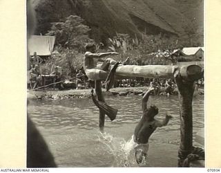 ZENAG, NEW GUINEA, 1944-02-27. A CONTEST IN THE GREASY POLE FIGHT AT A SPORTS CARNIVAL ARRANGED AT A CREEK DAMMED BY THE 2/9TH FIELD COMPANY, ROYAL AUSTRALIAN ENGINEERS. ATTENDED BY VISITORS FROM ..