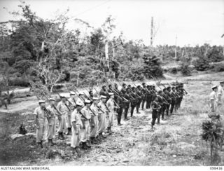 KAVIENGKAVIENG, NEW IRELAND. 1945-10-19. ROYAL AUSTRALIAN NAVY PERSONNEL AND MEMBERS OF THE ROYAL PAPUAN CONSTABULARY ON PARADE JUST BEFORE THE CEREMONY OF HOISTING THE AUSTRALIAN FLAG AT THE ..