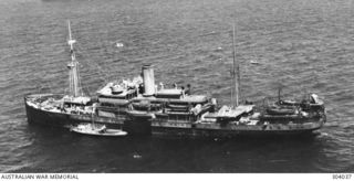 AERIAL PORT SIDE VIEW OF THE DUTCH CARGO VESSEL THEDENS WHICH TOOK PART IN OPERATION LILLIPUT IN EASTERN NEW GUINEA BETWEEN 1942-12 AND 1943-06. NOTE THE 12 POUNDER AA GUN MOUNTED ON THE STERN ..