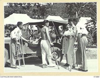 PORT MORESBY, NEW GUINEA. 1944-05-05. PATIENTS OF THE 2/1ST GENERAL HOSPITAL RECEIVING PACKETS OF BARLEY SUGAR AND CIGARETTES FROM B2/301 SUPERINTENDENT MISS S. GRAHAM (2) AND B2/359 ASSISTANT ..