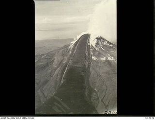 NEAR TOROKINA, BOUGAINVILLE ISLAND, SOLOMON ISLANDS. 1945-01-28. AERIAL VIEW OF LAVA FLOW FROM THE FAMILIAR LANDMARK BY WHICH RAAF PILOTS MAY CHECK THEIR BEARINGS, THE SMOULDERING ACTIVE VOLCANO ..